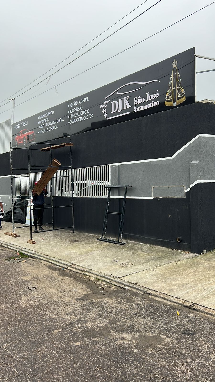 Equipe da CWB instalando painel de fachada sobre estrutura metálica em oficina automotiva
